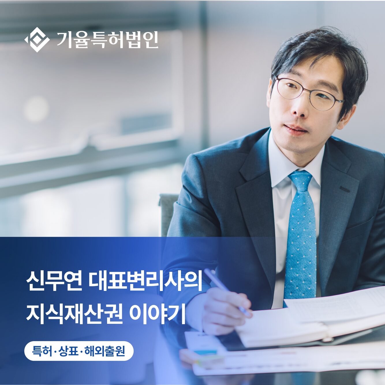 Professional Korean businessman in a suit wearing glasses, seated at a desk with documents; large blue overlay text covers the lower left area.