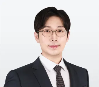 340x330_대표님 Professional portrait of a young Asian man in a dark suit, white shirt, and patterned tie, wearing glasses and looking at the camera.